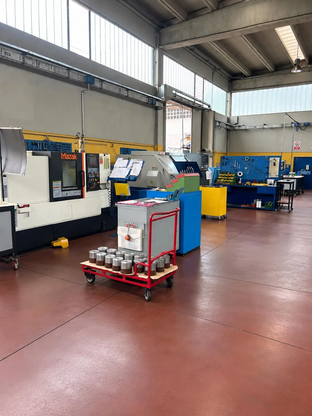 Il reparto MA.MEK.: torni CNC, banchi e carrello con pezzi torniti sul pavimento rosso
